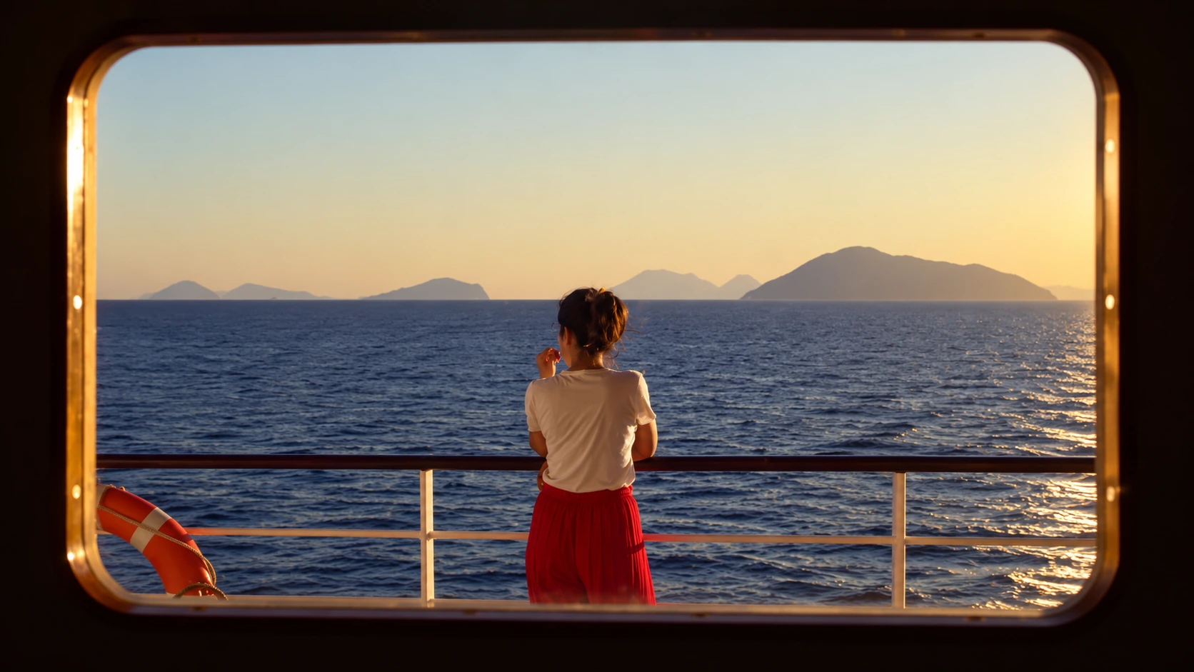 Woman watching the sea at sunset from a ship deck framed by a window