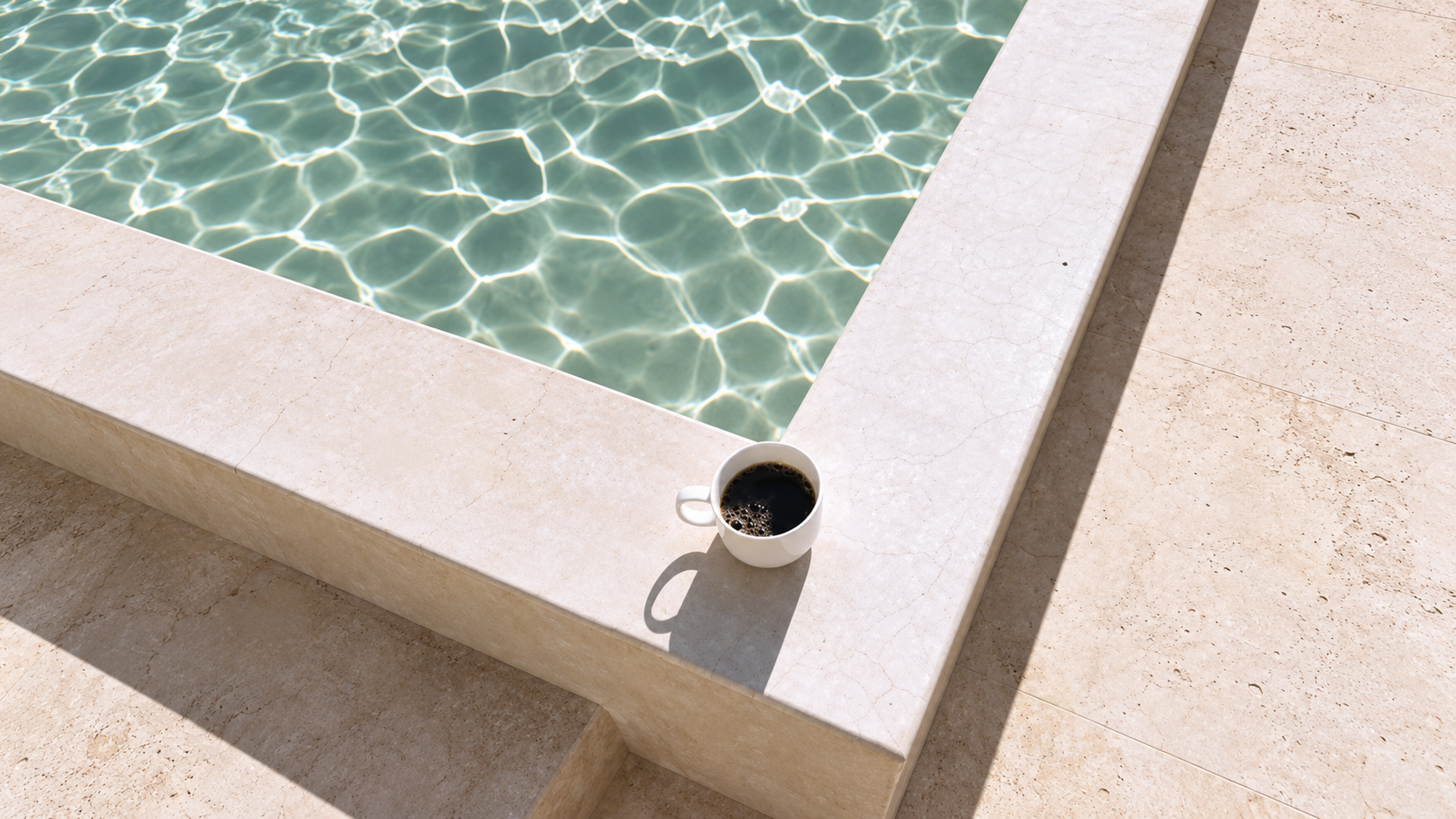 Coffee beside a sunlit swimming pool