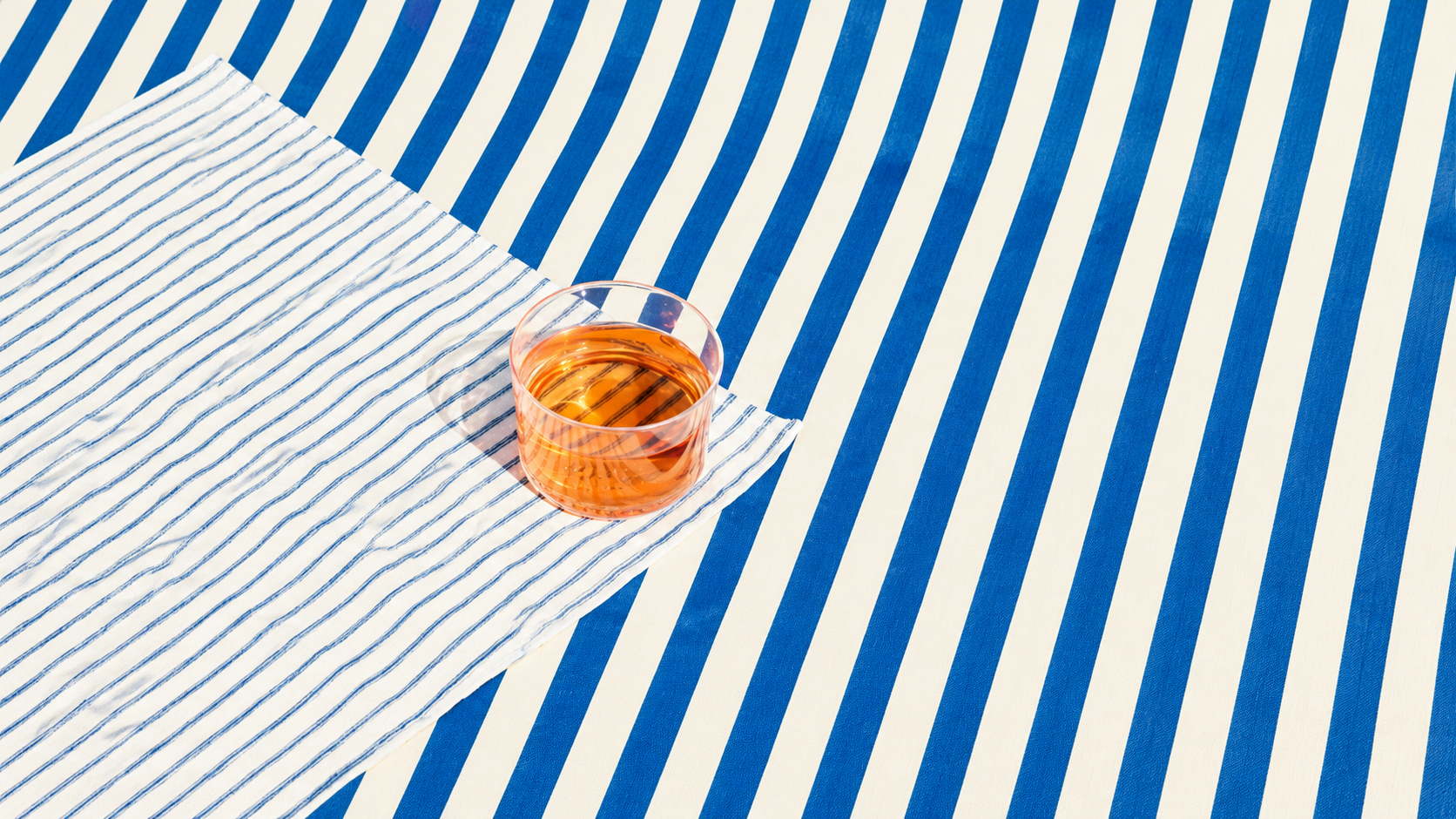 Amber drink on blue and white striped fabric
