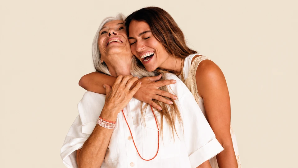 Two women smiling and sharing a warm embrace