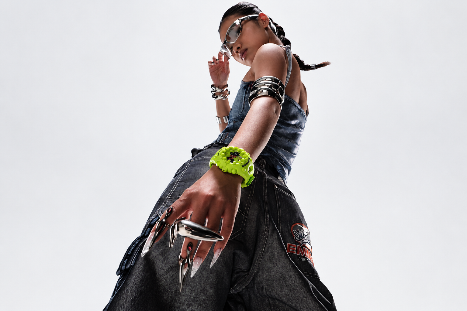 Low-angle fashion portrait with silver accessories and a neon green watch