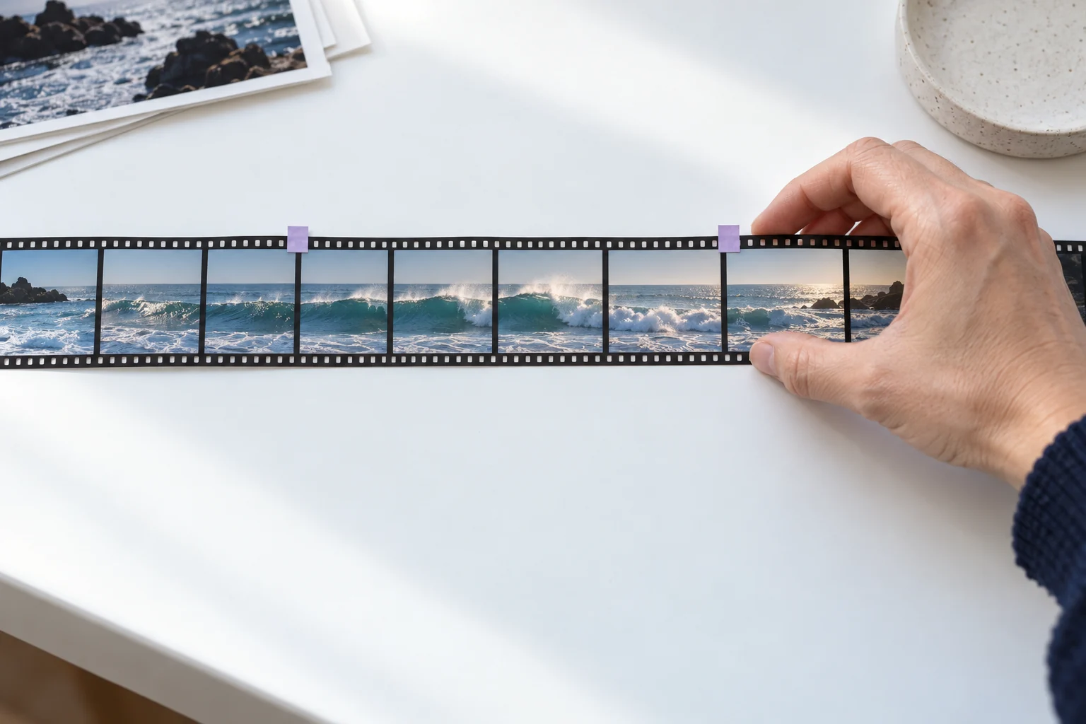 Original AI illustration of an ocean-film strip with a selected middle sequence marked by lavender paper tabs